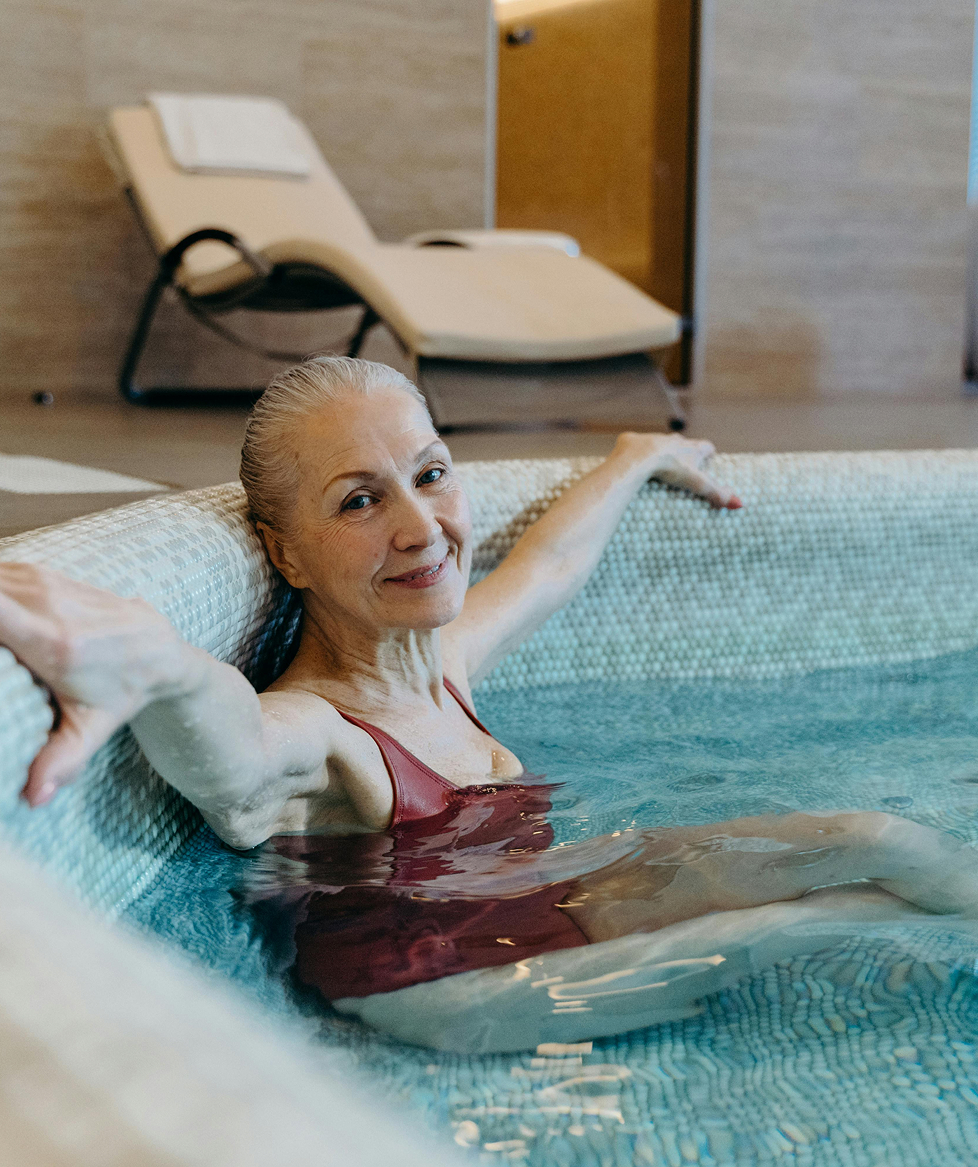 Eine Frau sitzt entspannt im Whirlpool