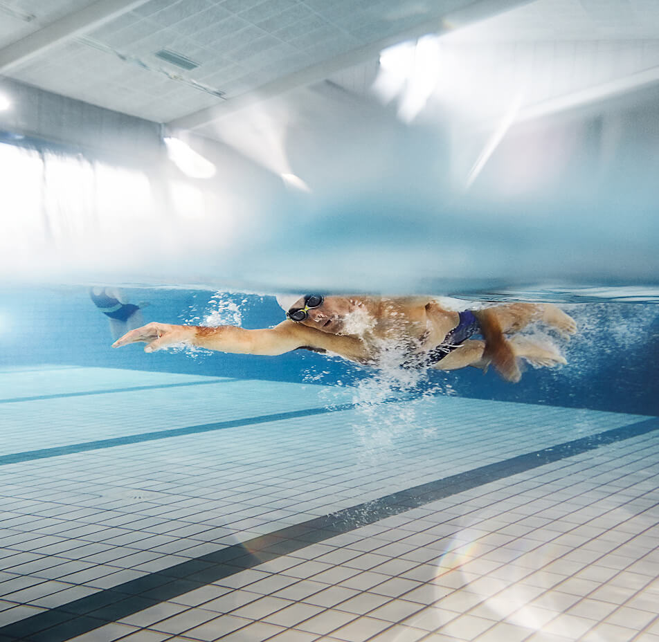Ein Mann taucht durch ein tiefes Schwimmbecken