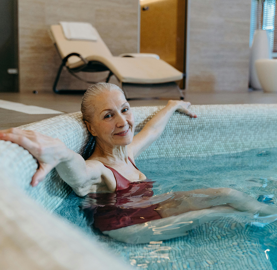 Eine Frau sitzt entspannt im Whirlpool